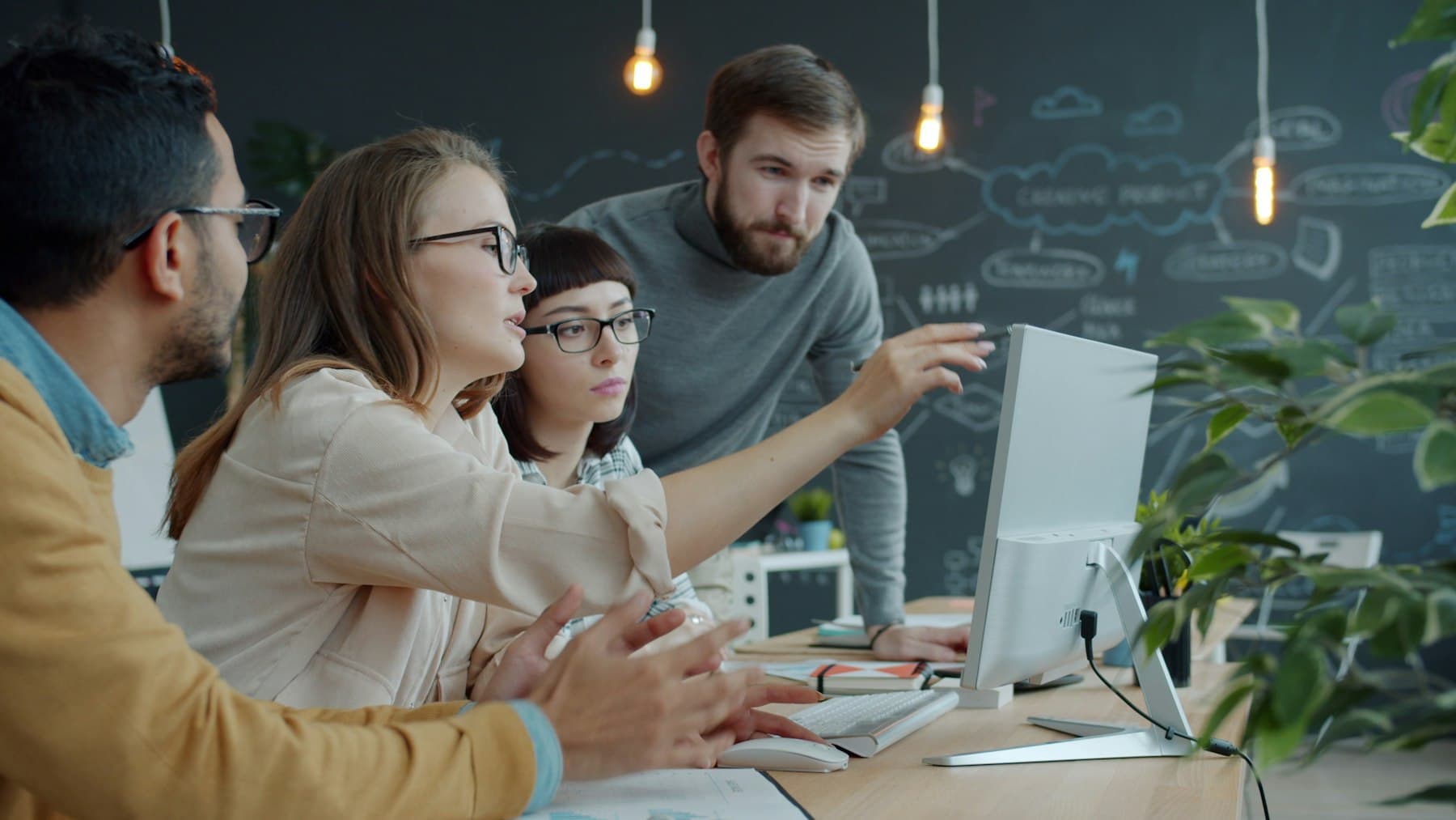 A team reviewing work together around a computer